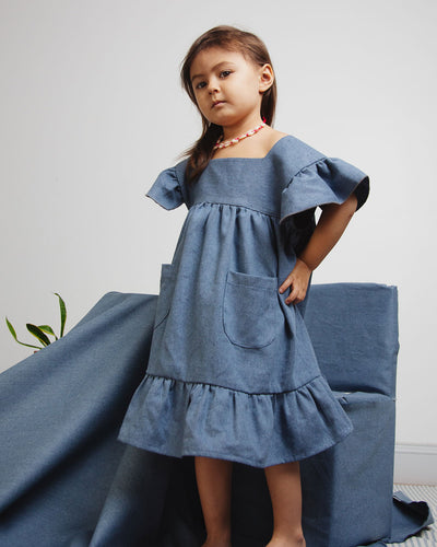 Girl Denim dress with ruffle edged hem and ruffle shoulders details.